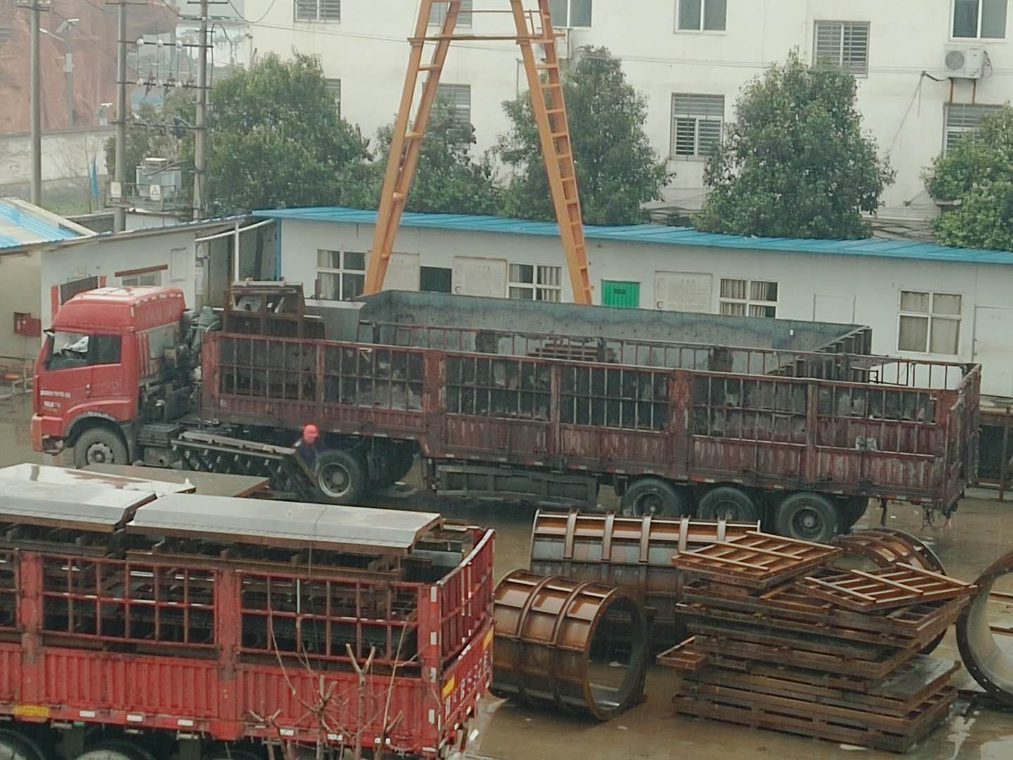 下雨天，系梁模板廠家的員工冒雨裝貨